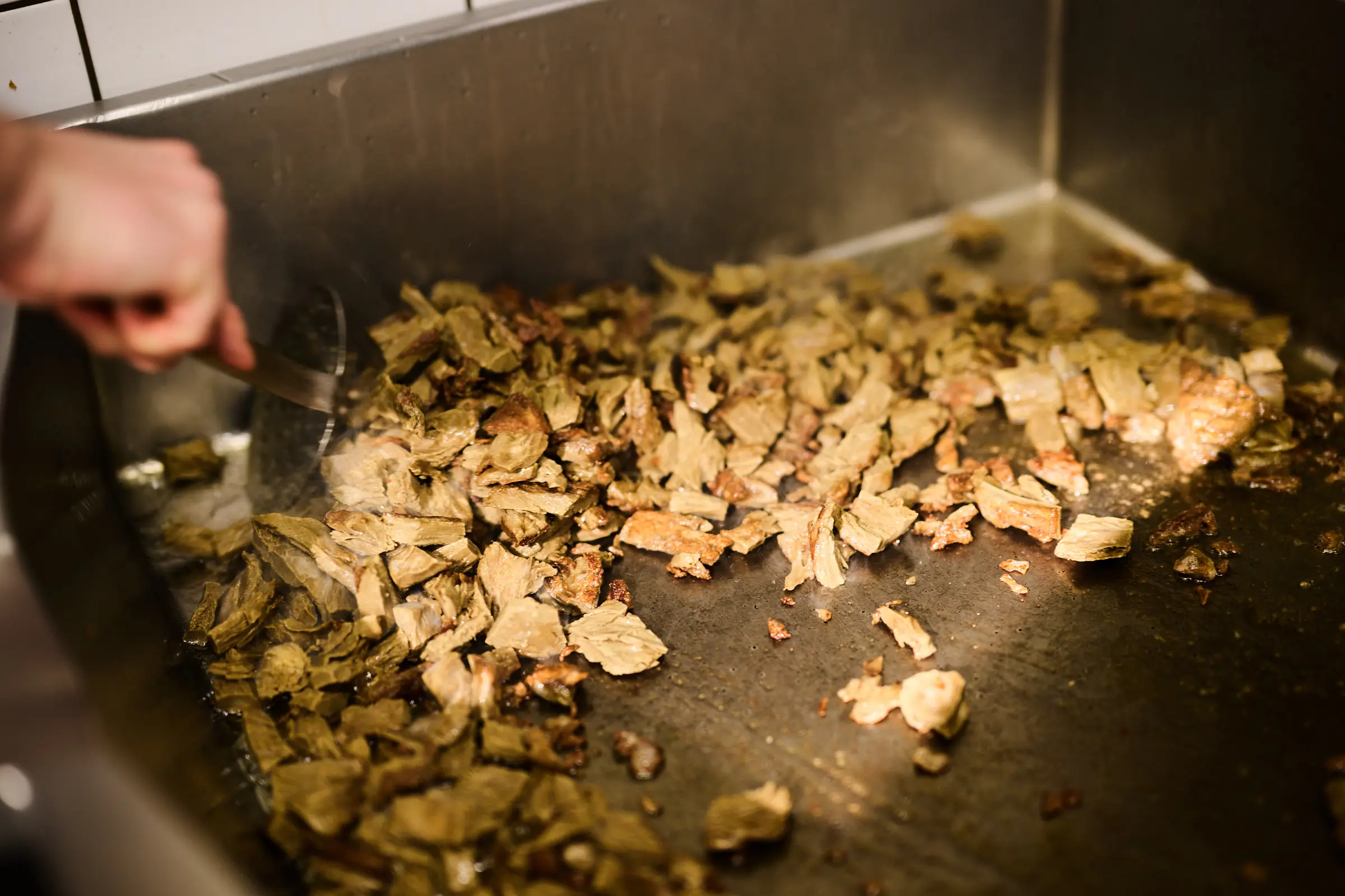 Brew Chunks werden in der Großküche mit der Lochkelle angebraten
