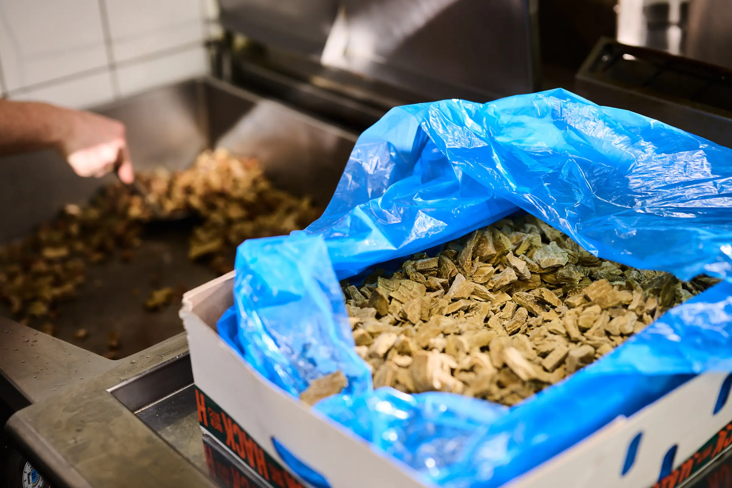 Großküche: Brew Chunks aus dem Karton, daneben brät die erste Portion auf der Platte